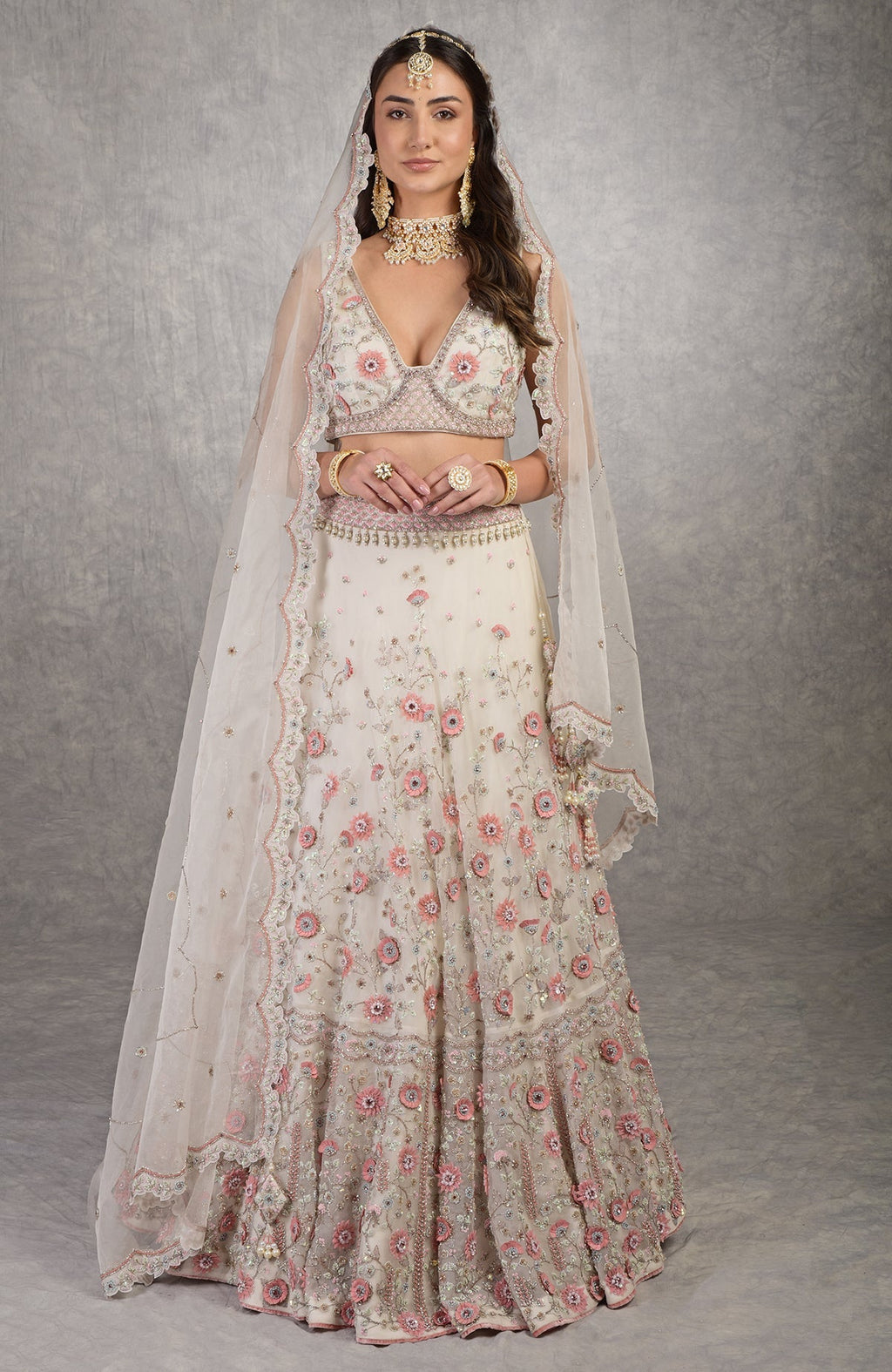 Off-white lehenga set with 3-D pink floral embroidery and crystal bead embellishments.
