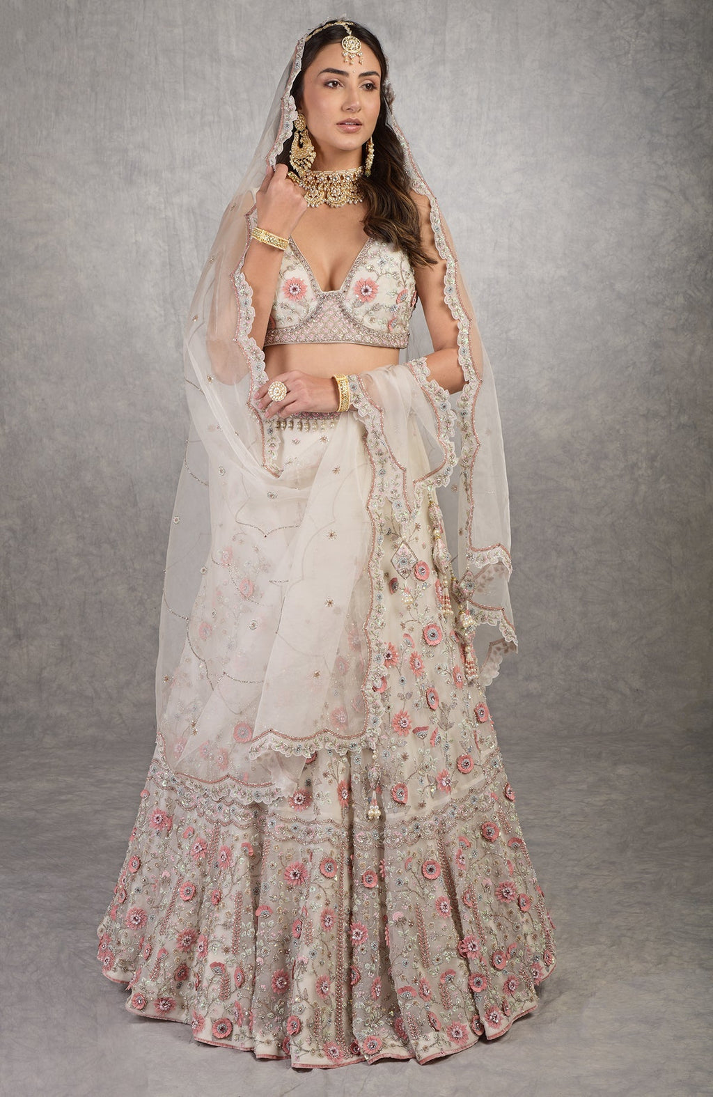 Off-white lehenga set with 3-D pink floral embroidery and crystal bead embellishments.