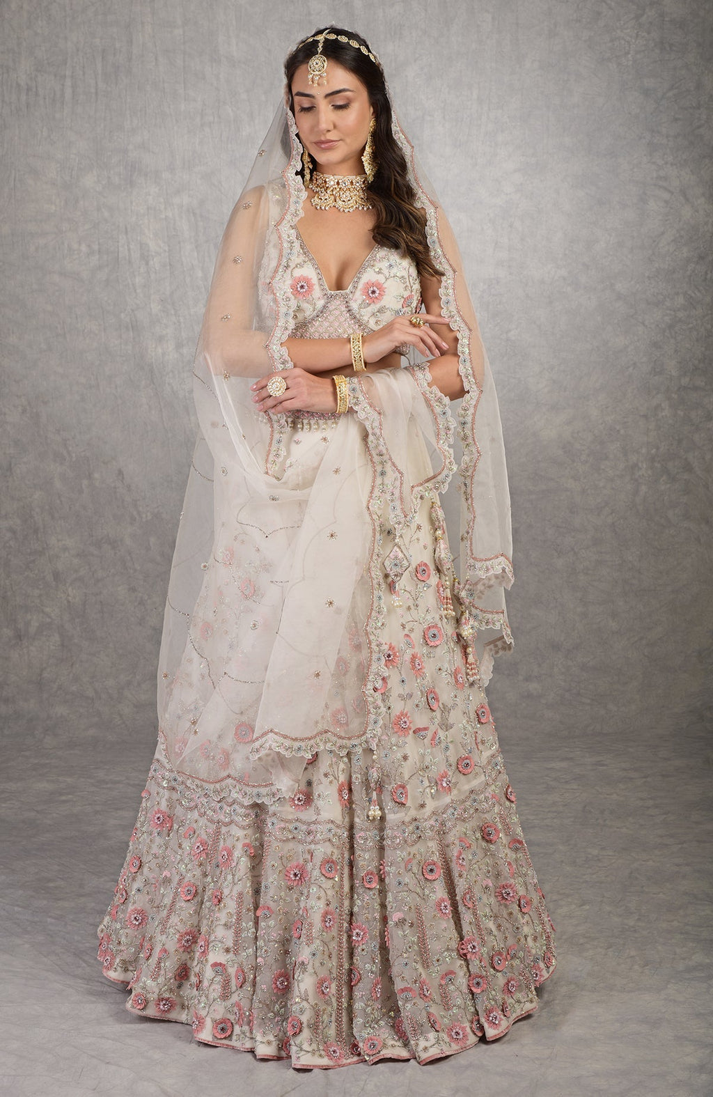 Off-white lehenga set with 3-D pink floral embroidery and crystal bead embellishments.