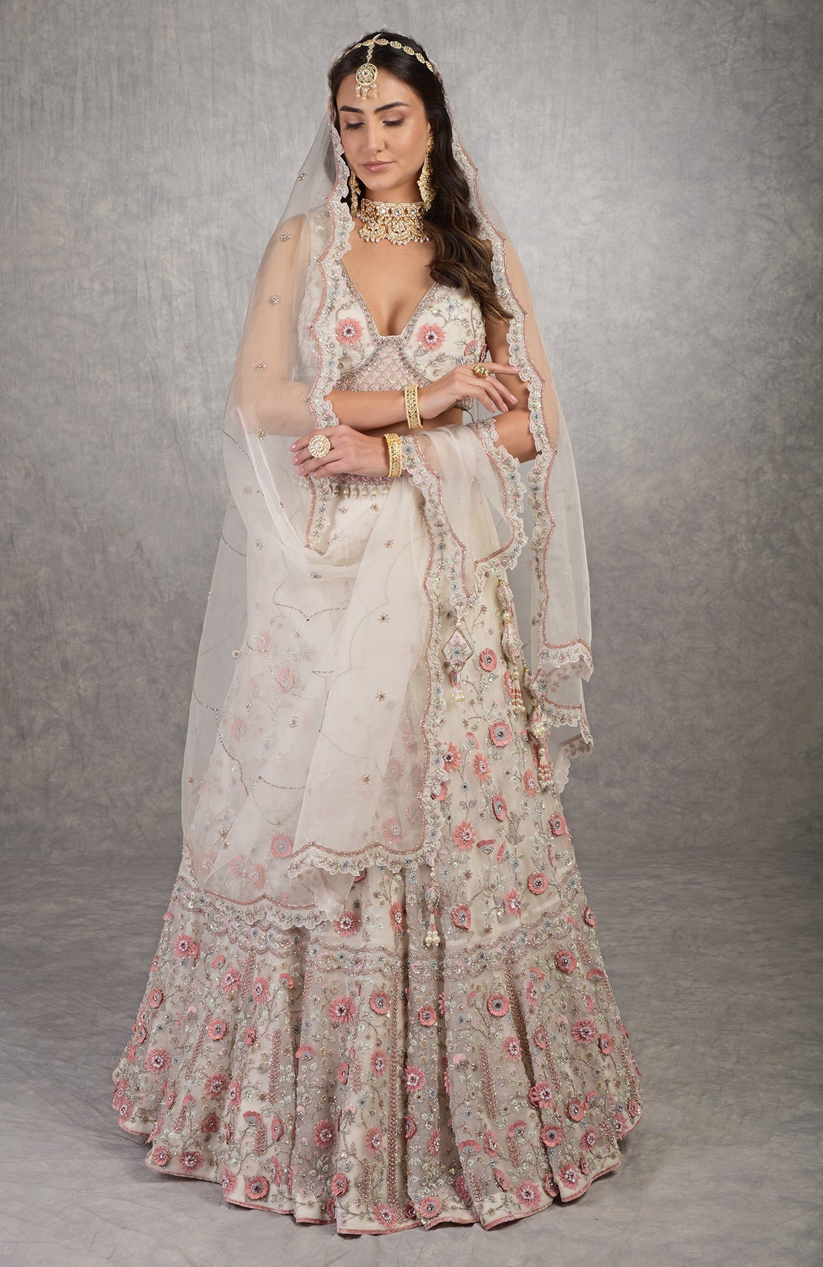 Off-white lehenga set with 3-D pink floral embroidery and crystal bead embellishments.