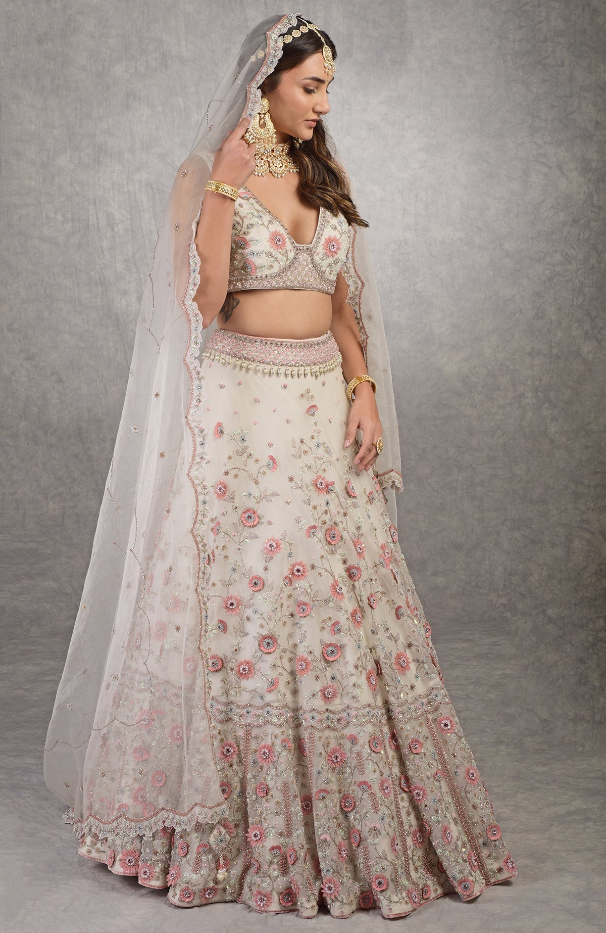 Off-white lehenga set with 3-D pink floral embroidery, crystal beadwork, and silk organza fabric.
