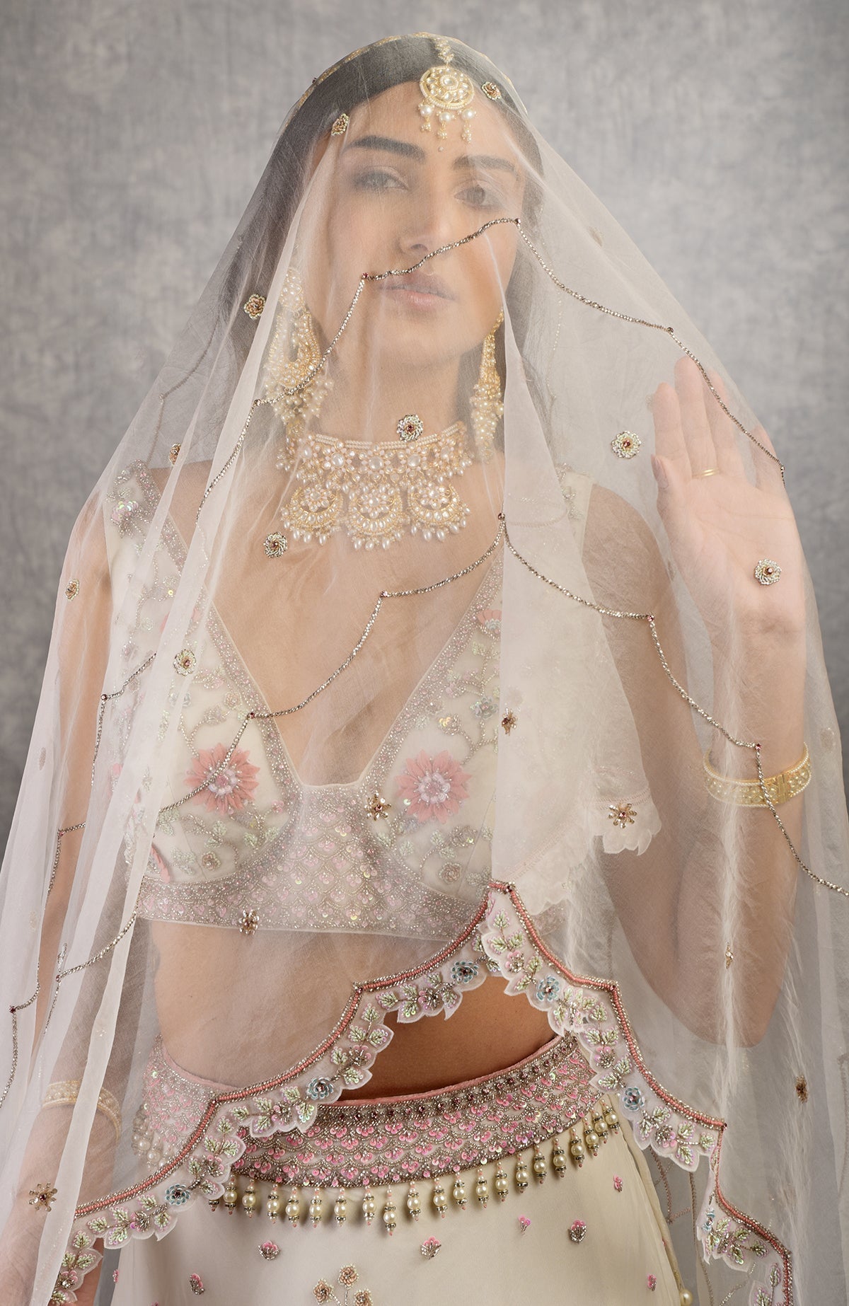 Off-white lehenga set with 3-D pink floral embroidery and crystal bead embellishments.