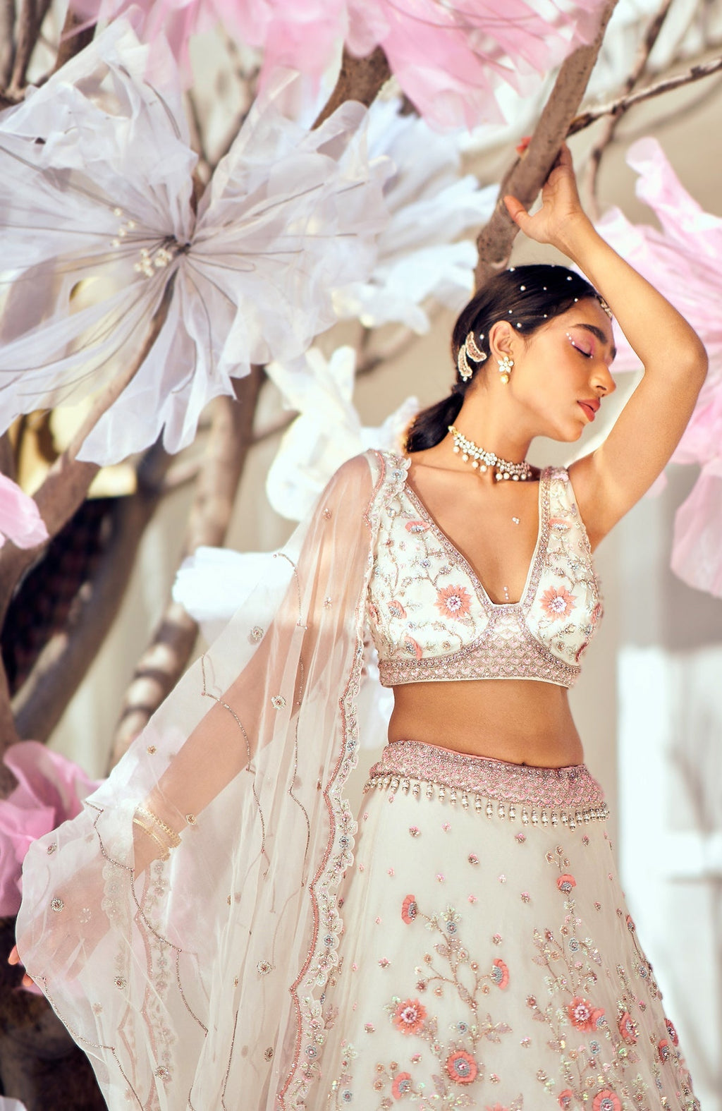 Off-white lehenga set with 3-D pink floral embroidery and crystal bead embellishments.