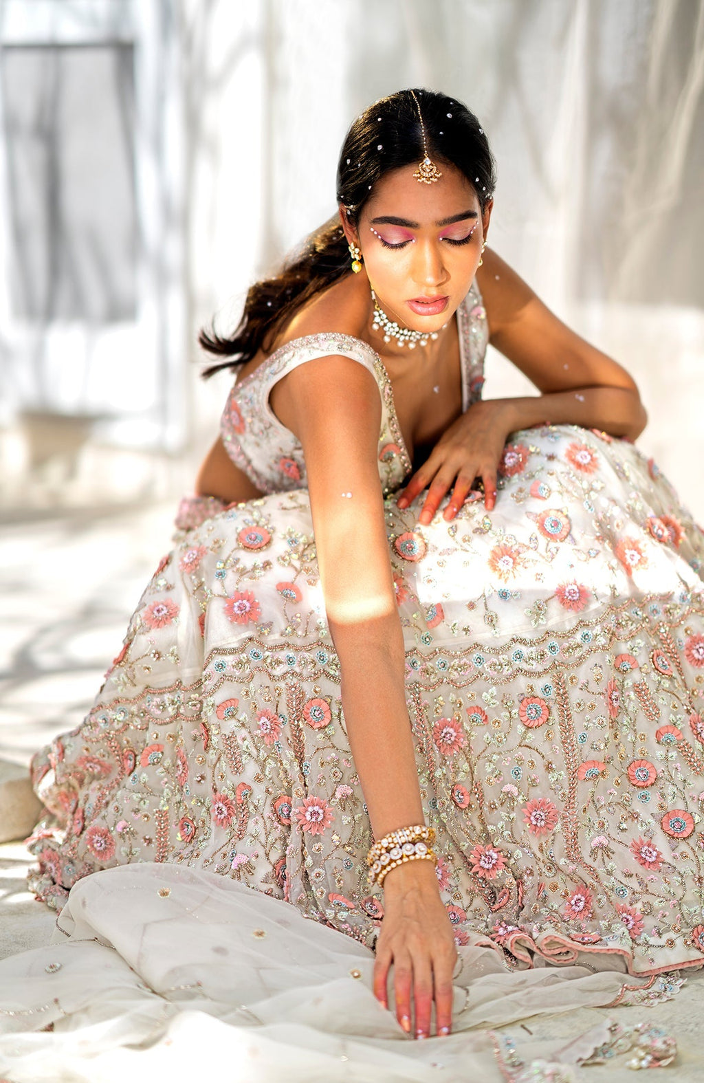 Off-white lehenga set with 3-D pink floral embroidery on silk organza and crystal bead details.