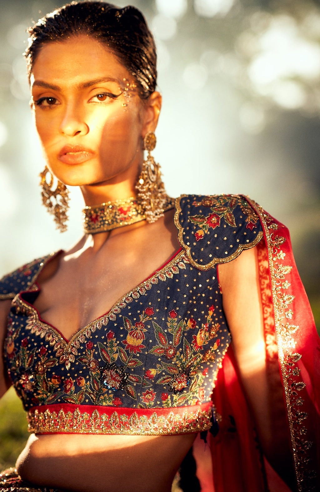 Classic blue lehenga with mustard floral embroidery, gold zardozi, and red silk organza dupatta.