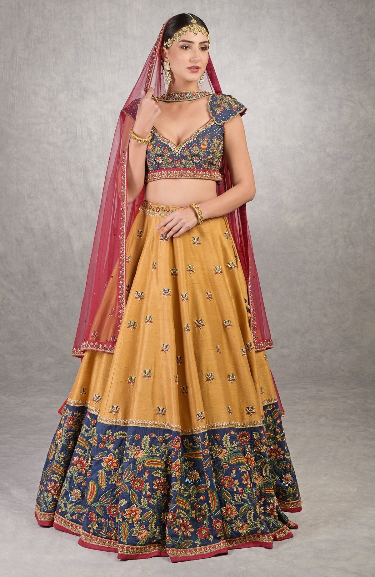 Classic blue lehenga with intricate floral embroidery, gold zardozi, and mustard accents.