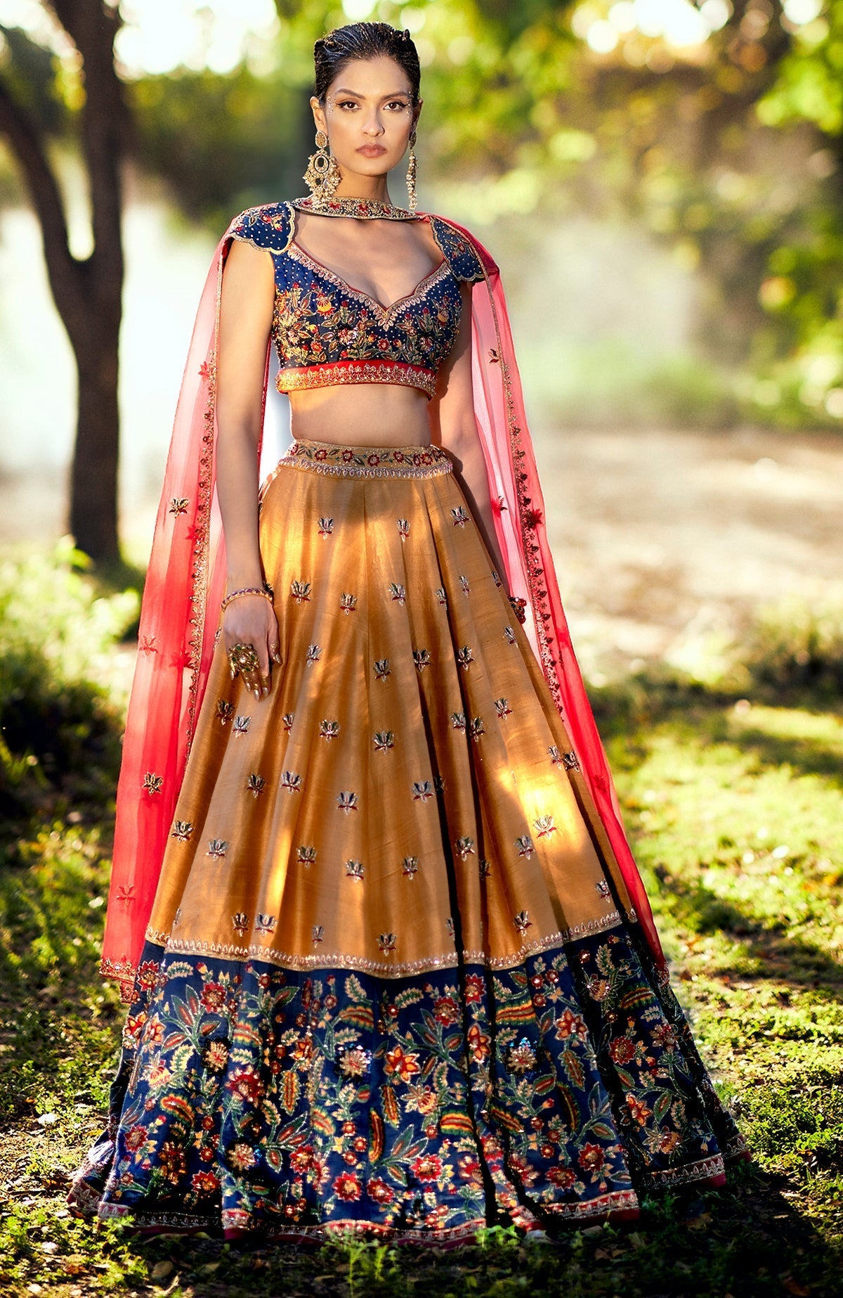 Classic blue lehenga with mustard embroidery, floral motifs, and red-yellow-green resham accents.