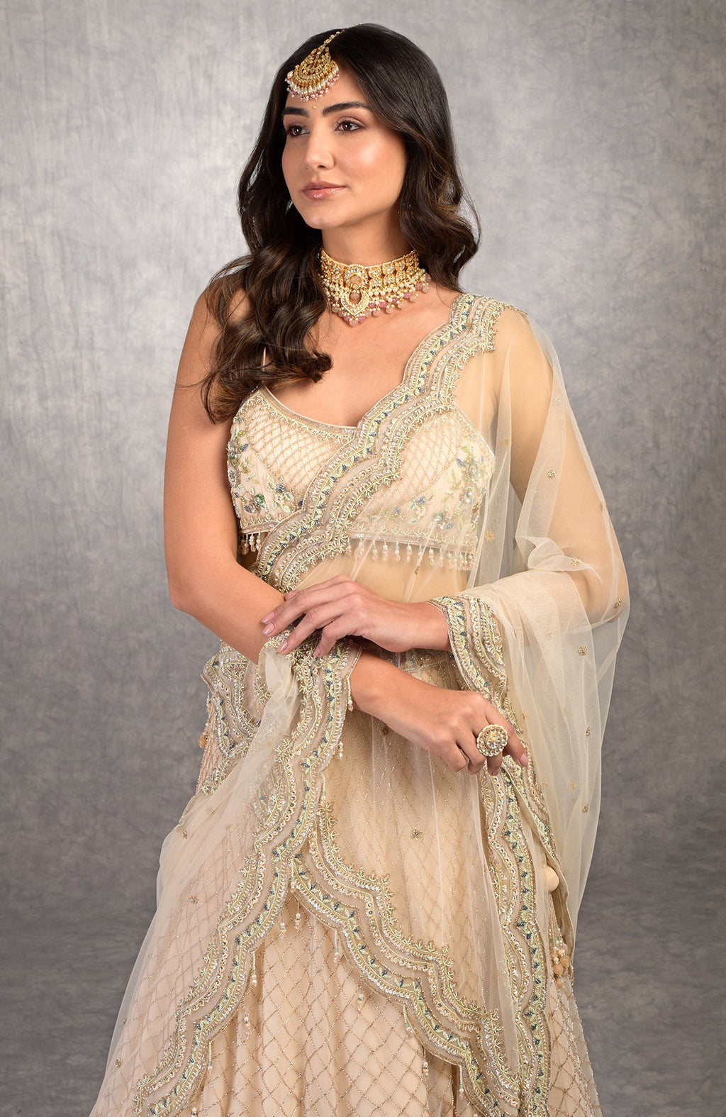 Champagne pink lehenga set with floral bead embroidery, scoop neck blouse, and scalloped tulle veil.