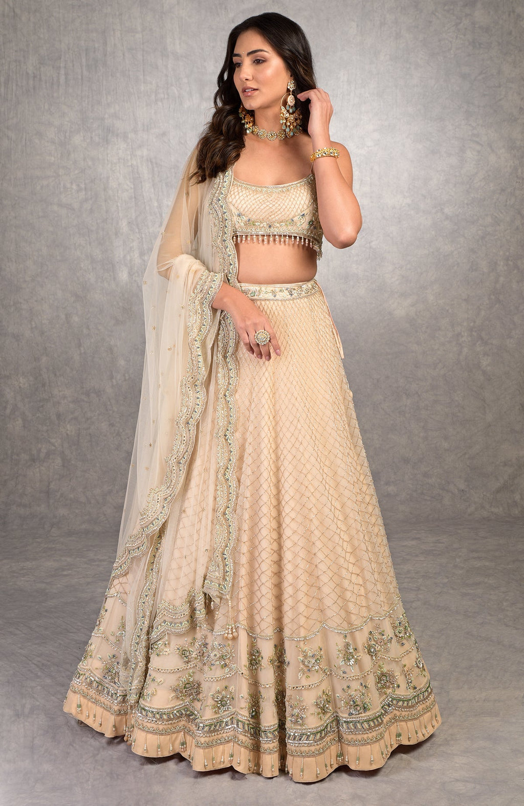 Champagne pink lehenga set with floral bead embroidery, scalloped tulle veil, and scoop neck blouse.