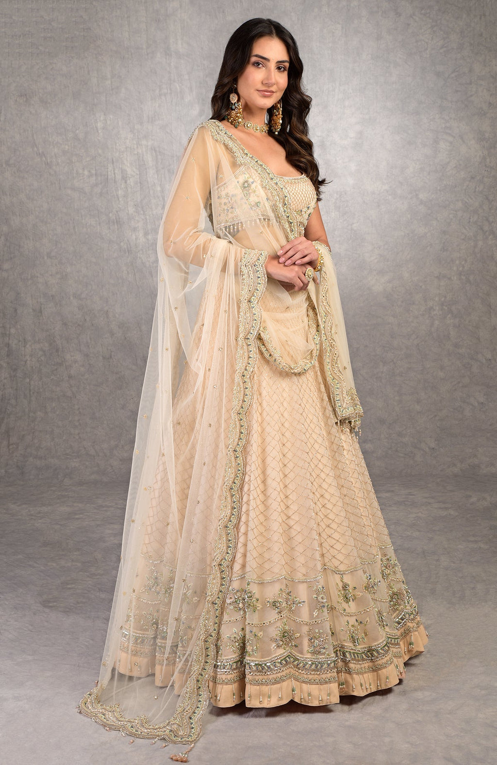 Champagne pink lehenga set with floral bead embroidery, scoop neck blouse, and scalloped tulle veil.