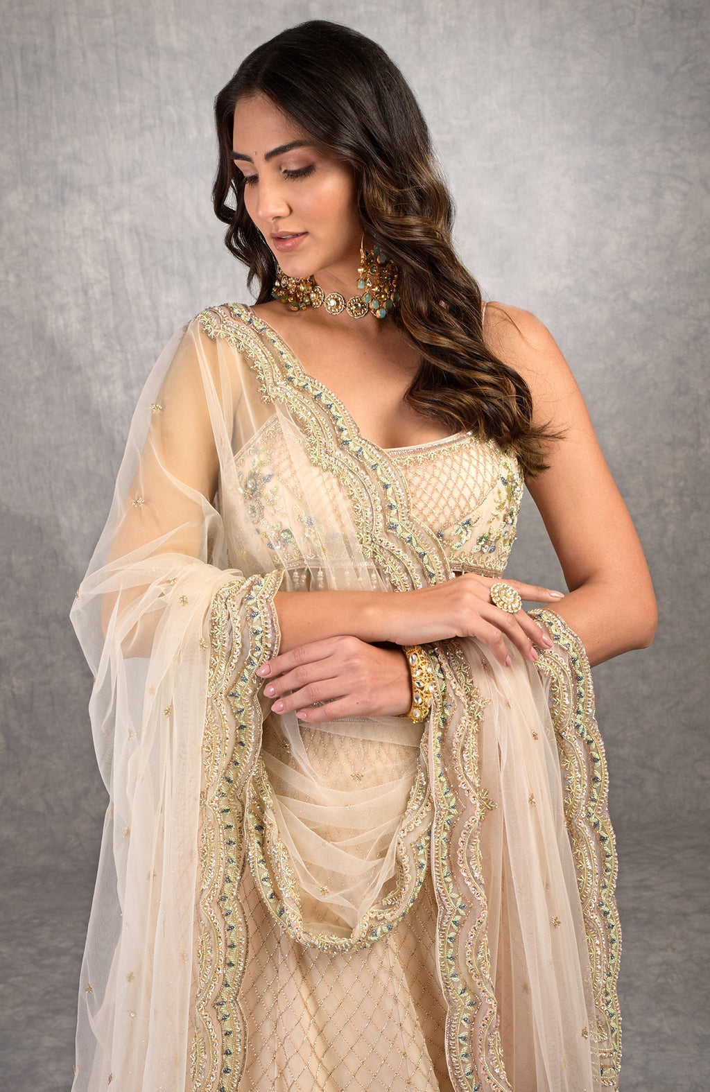 Champagne pink lehenga set with floral bead embroidery, scoop neck blouse, and scalloped tulle veil.