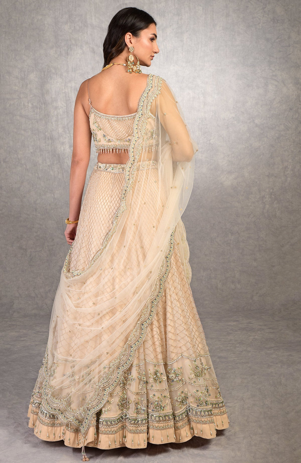 Champagne pink lehenga set with floral bead embroidery, scoop neck blouse, and scalloped tulle veil.