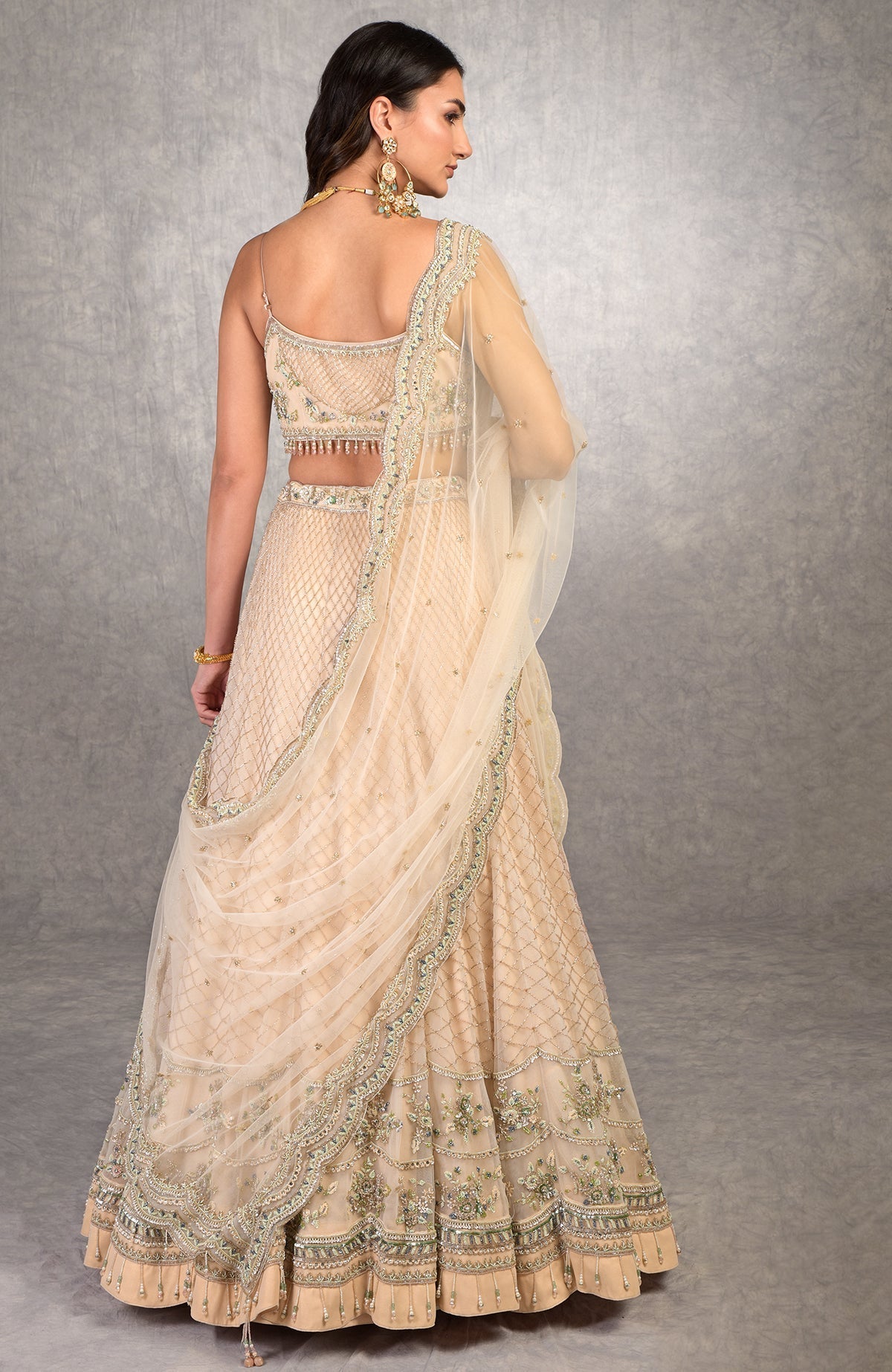 Champagne pink lehenga set with floral bead embroidery, scoop neck blouse, and scalloped tulle veil.