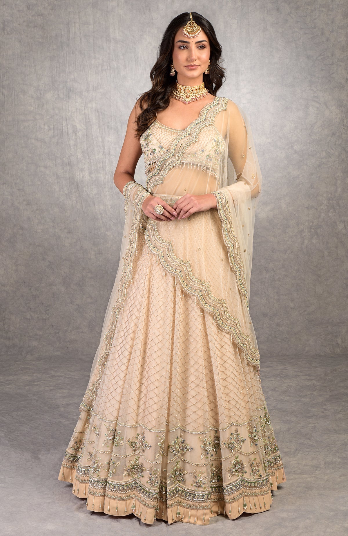 Champagne pink lehenga set with floral bead embroidery, scoop neck blouse, and scalloped tulle veil.