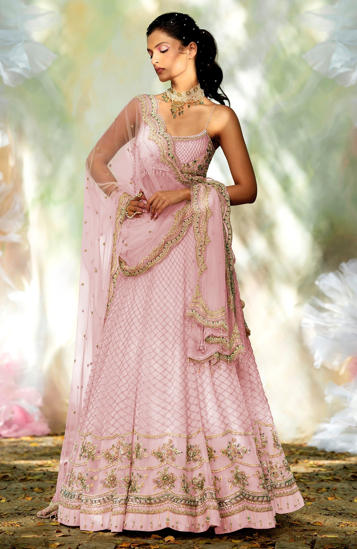 Champagne pink lehenga set with hand-embroidered floral motifs, crystals, beads, and scalloped tulle veil.