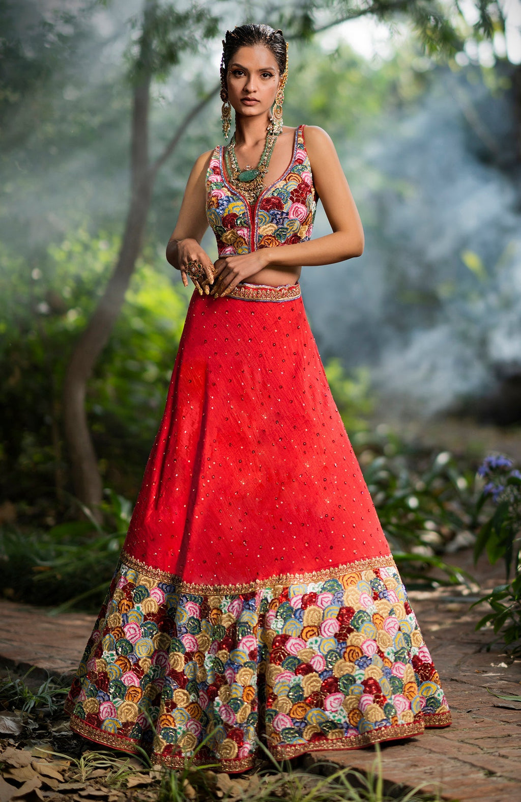 Red raw silk lehenga with multicolor floral embroidery, beadwork, and a sweetheart neck blouse.