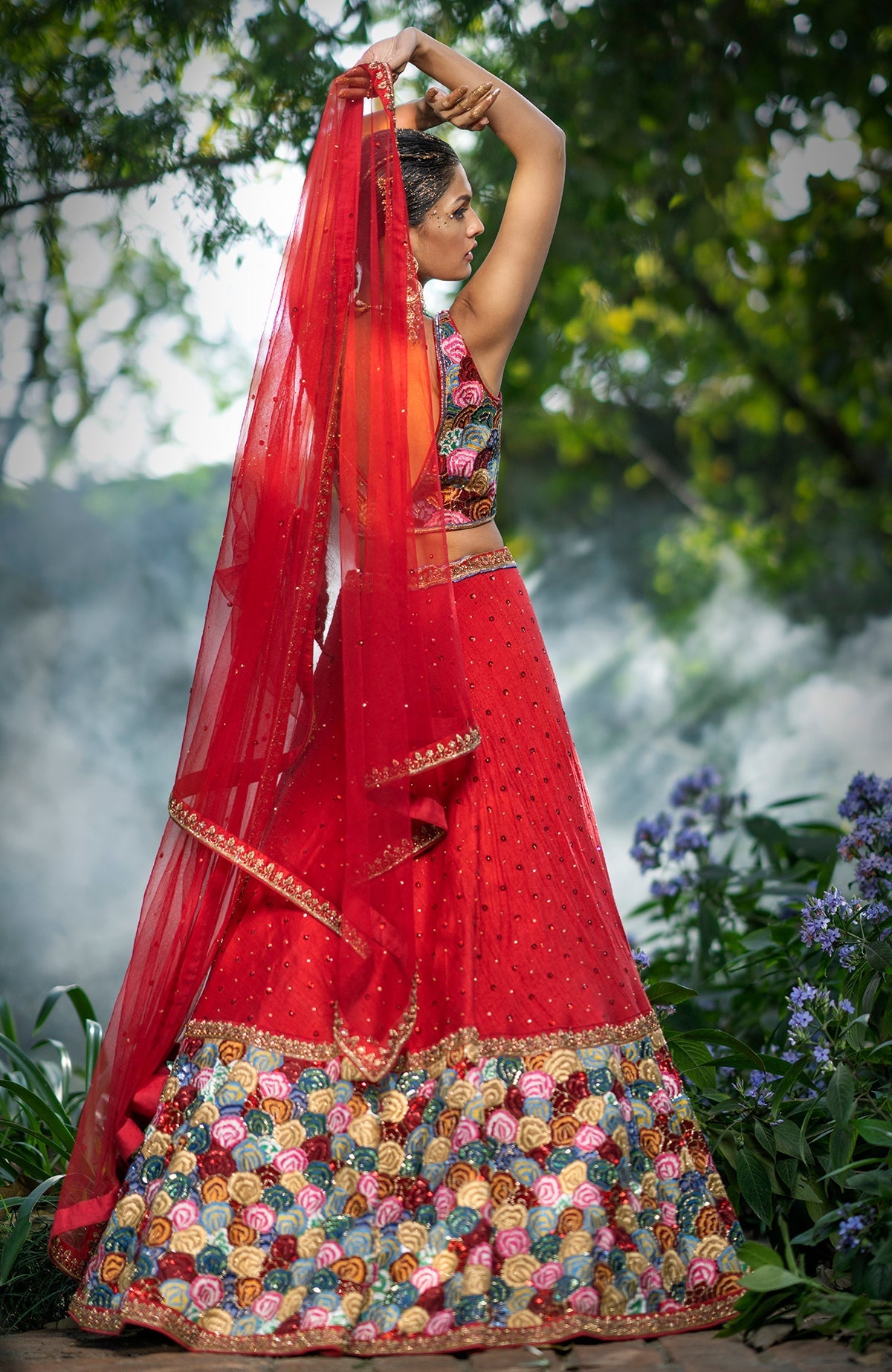 Red raw silk lehenga with multicolor floral embroidery, beadwork, sequin, and gold zardozi accents.