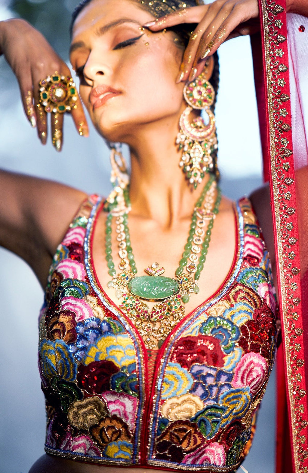 Red raw silk lehenga with multicolor floral embroidery, beadwork, and sweetheart neck blouse.