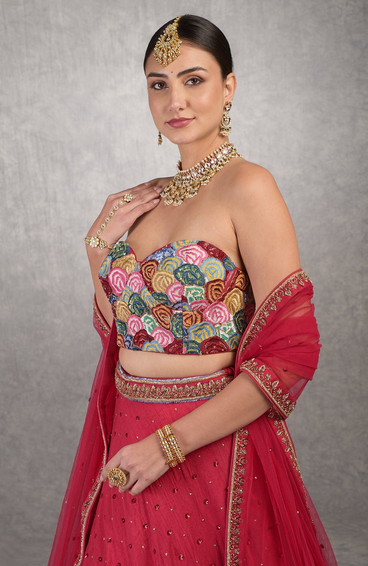 Red corset blouse with multicolor resham embroidery and floral bead and sequin details.