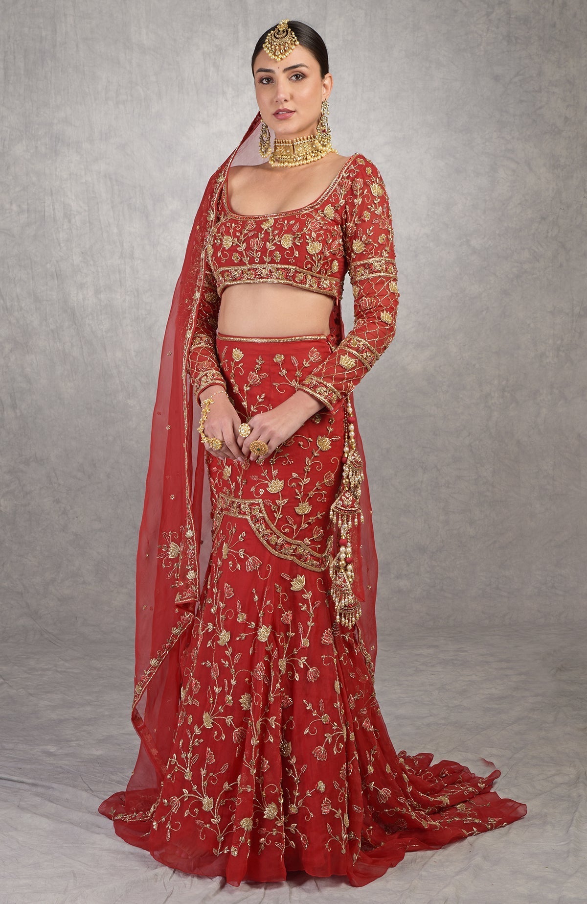Red fish-cut lehenga set with hand-embroidered lotus motifs and sheer full-sleeve scoop neck blouse.