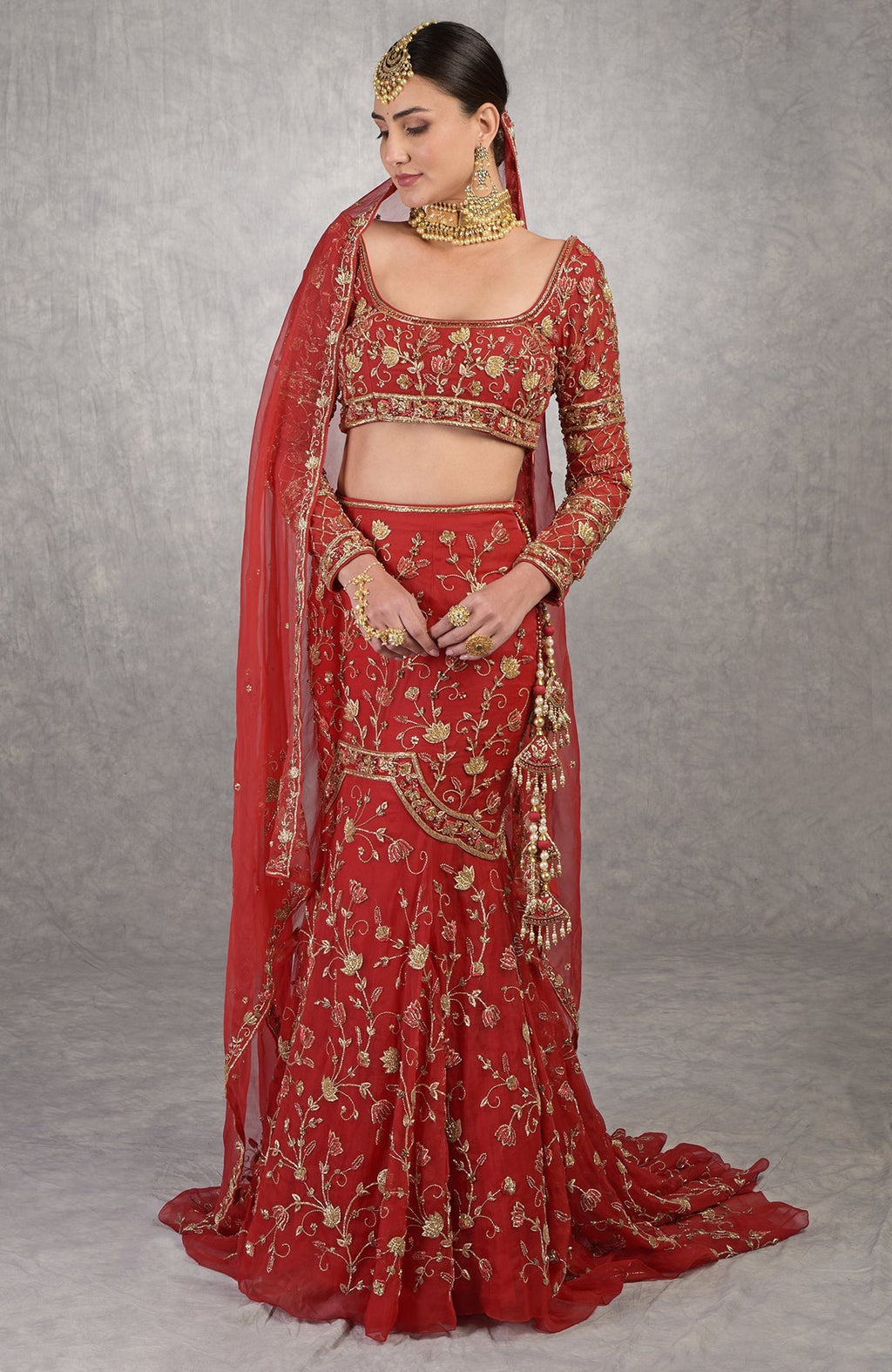 Red fish-cut lehenga set with hand-embroidered lotus motifs and sheer full-sleeve blouse.
