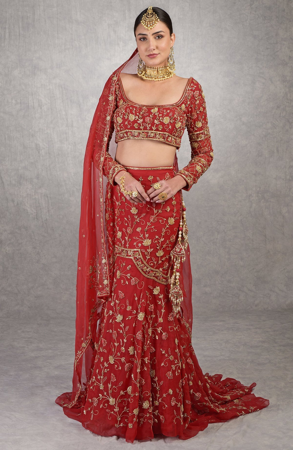 Red fish-cut lehenga set with hand-embroidered lotus motifs and sheer full-sleeve blouse.