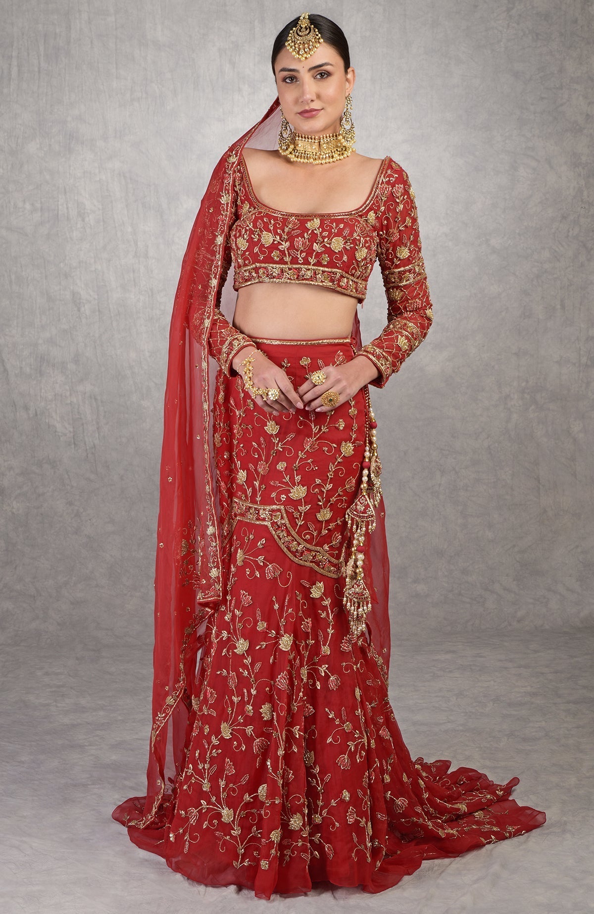Red fish-cut lehenga set with hand-embroidered lotus motifs and sheer full-sleeve blouse.
