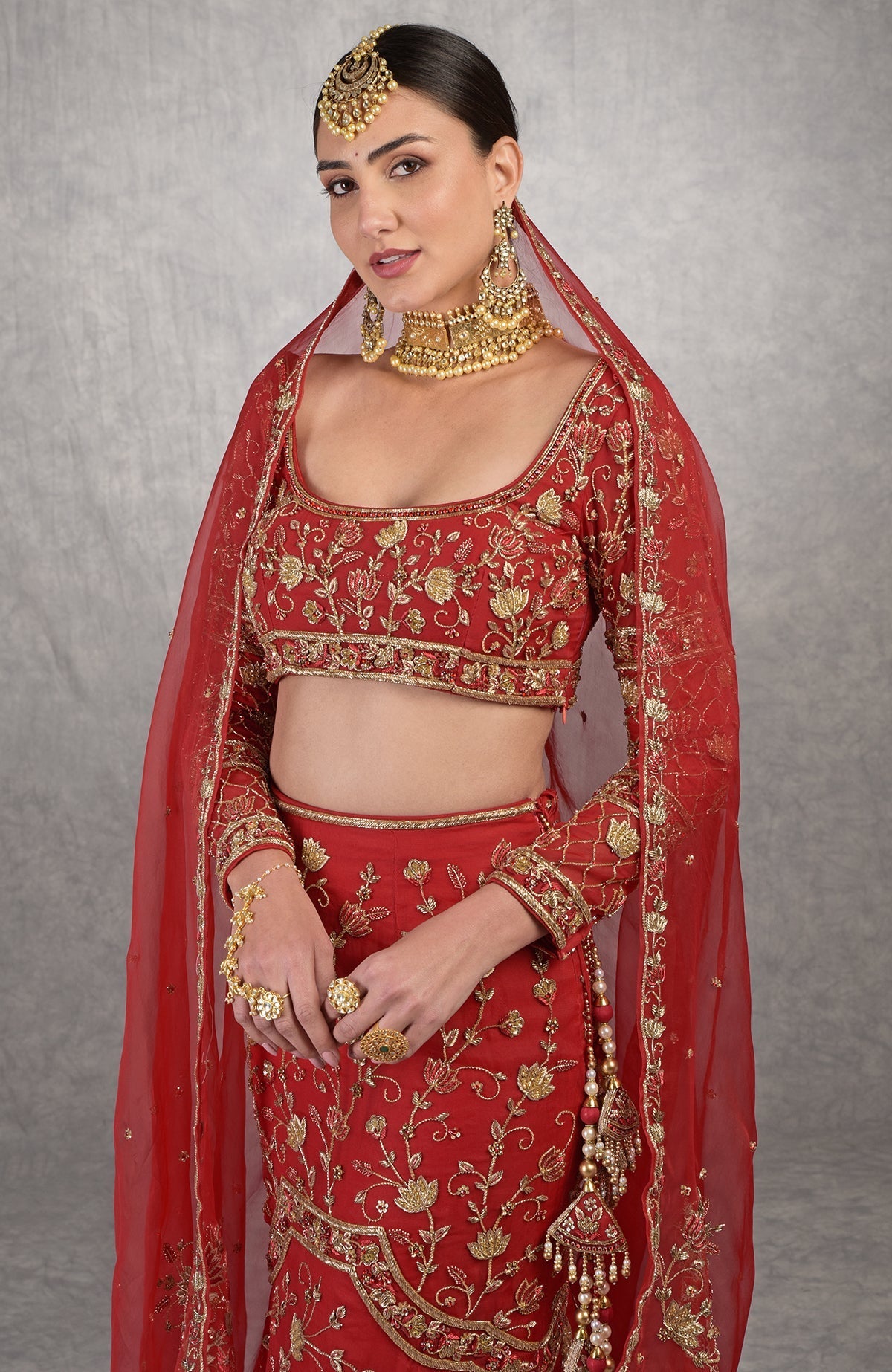 Red fish-cut lehenga set with hand-embroidered lotus motifs and sheer organza full sleeves blouse.