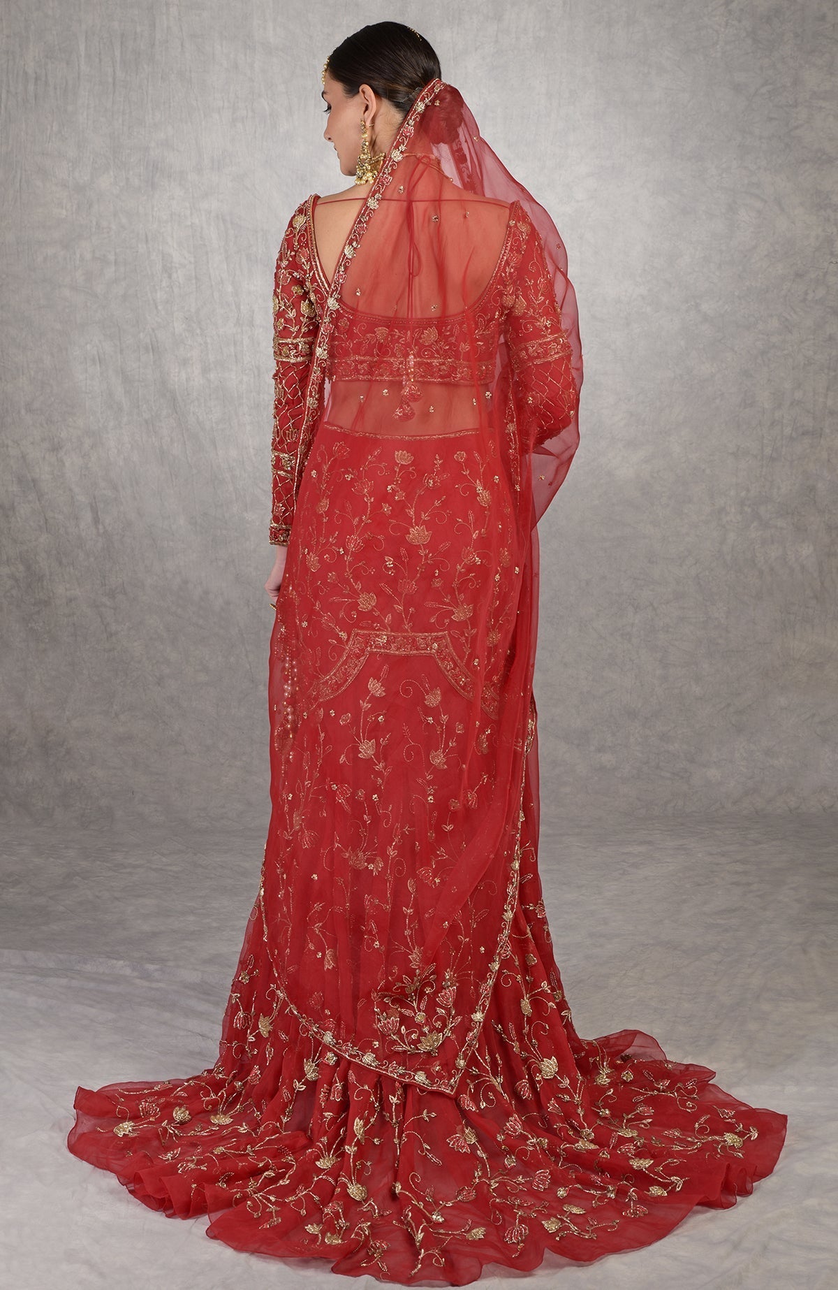 Red fish-cut lehenga set with hand-embroidered lotus motifs and sheer full-sleeve blouse.