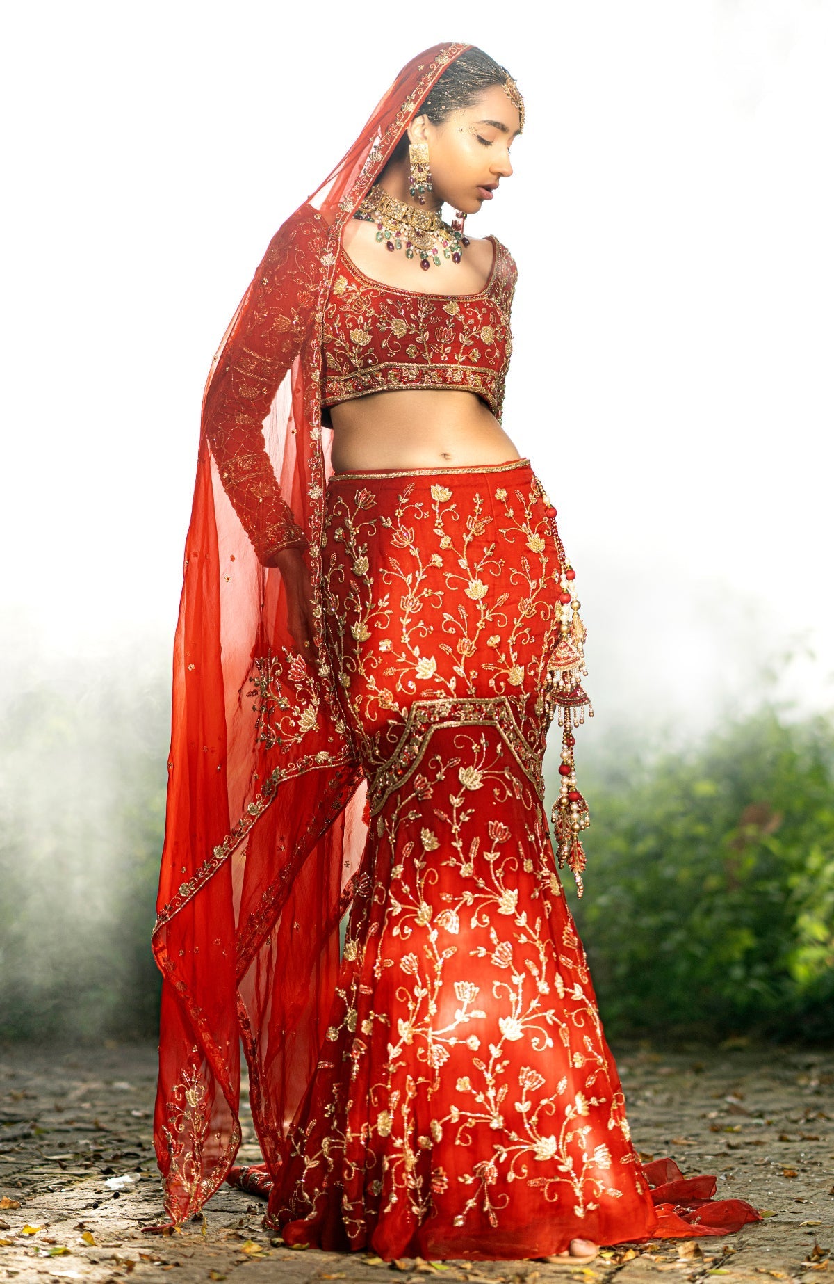 Red fish-cut lehenga set with hand-embroidered lotus motifs and sheer full-sleeve blouse.
