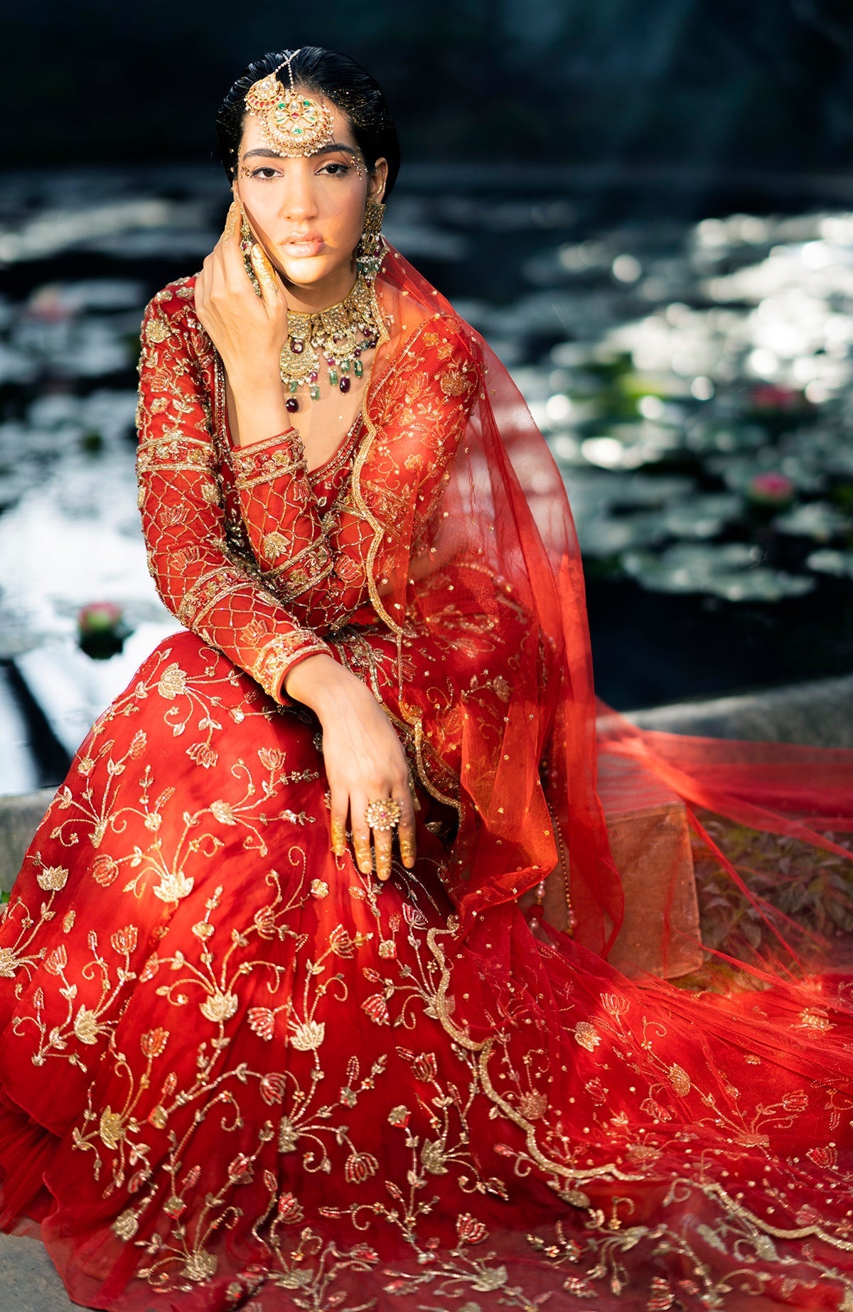Red fish-cut lehenga set with hand-embroidered lotus motifs and sheer organza full sleeves blouse.