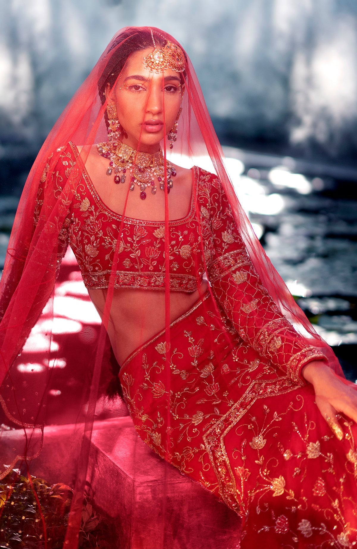 Red fish-cut lehenga set with hand-embroidered lotus motifs and sheer full-sleeve blouse.