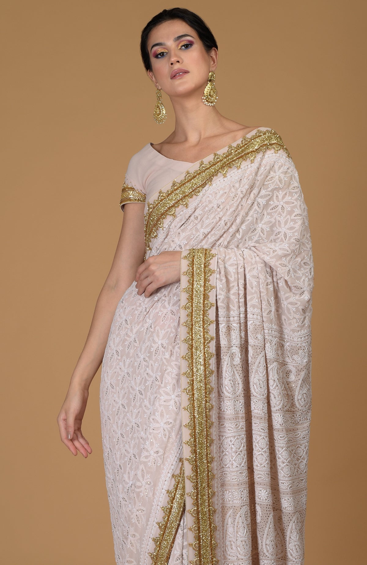 Nude pink Georgette saree with hand-embroidered Lucknowi Chikankari and gold zardozi details