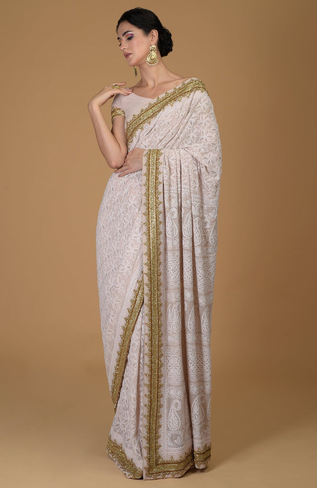 Nude pink Georgette saree with hand-embroidered Lucknowi Chikankari and gold zardozi details