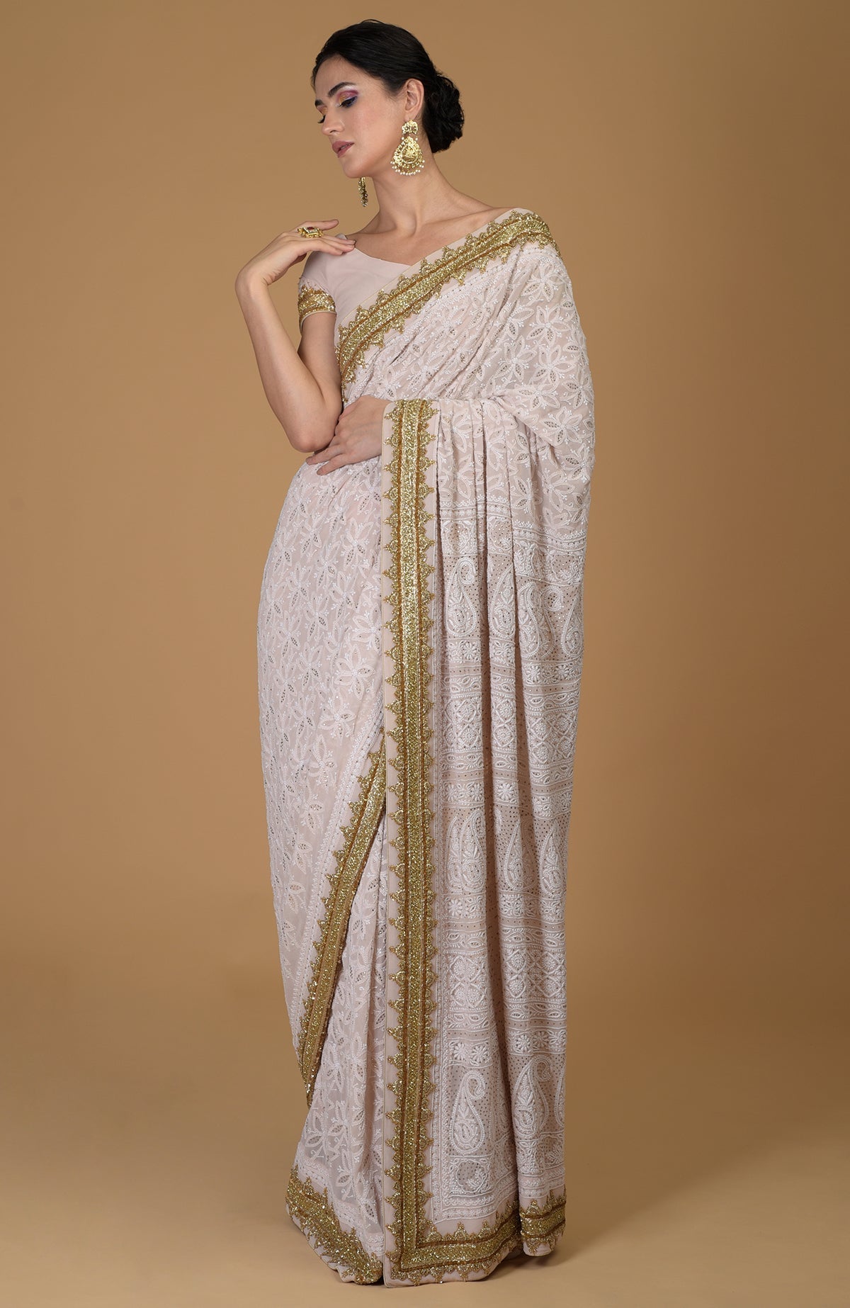 Nude pink Georgette saree with hand-embroidered Lucknowi Chikankari and gold zardozi details