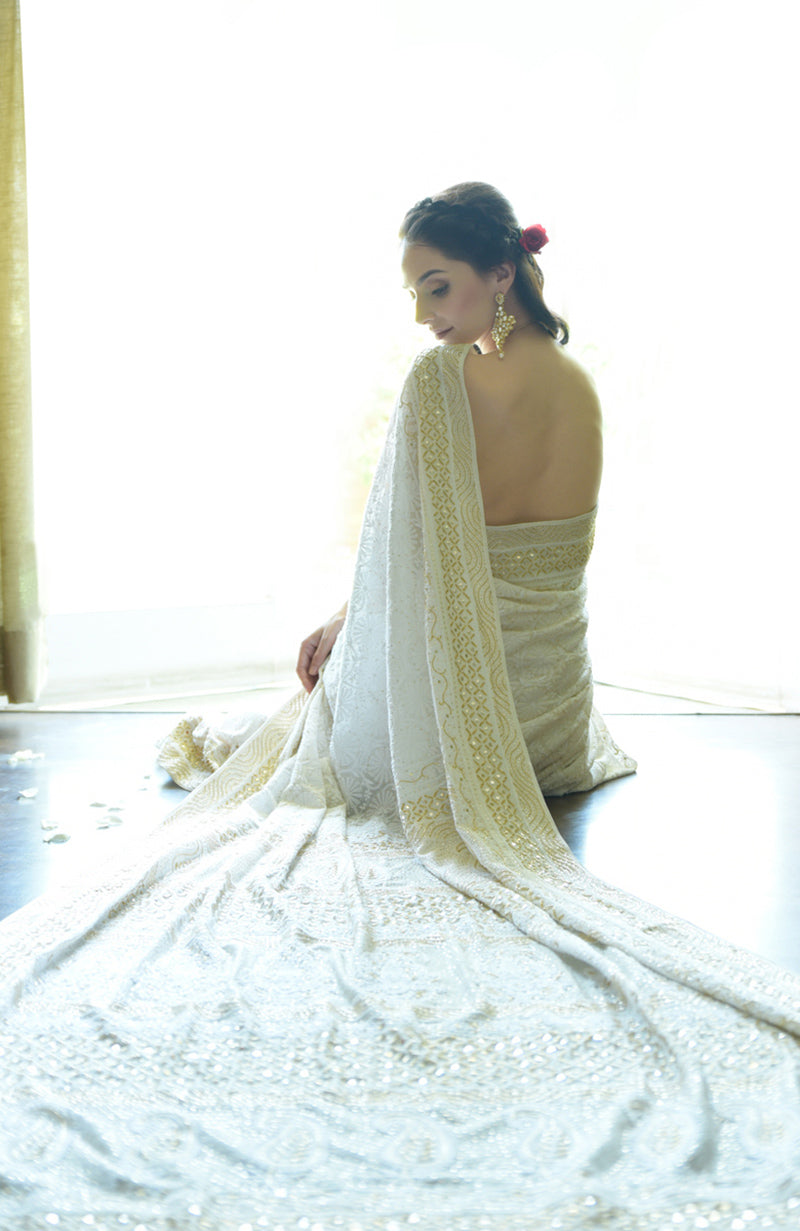 Ivory georgette saree with intricate floral Chikankari and gold cut dana embroidery on borders.