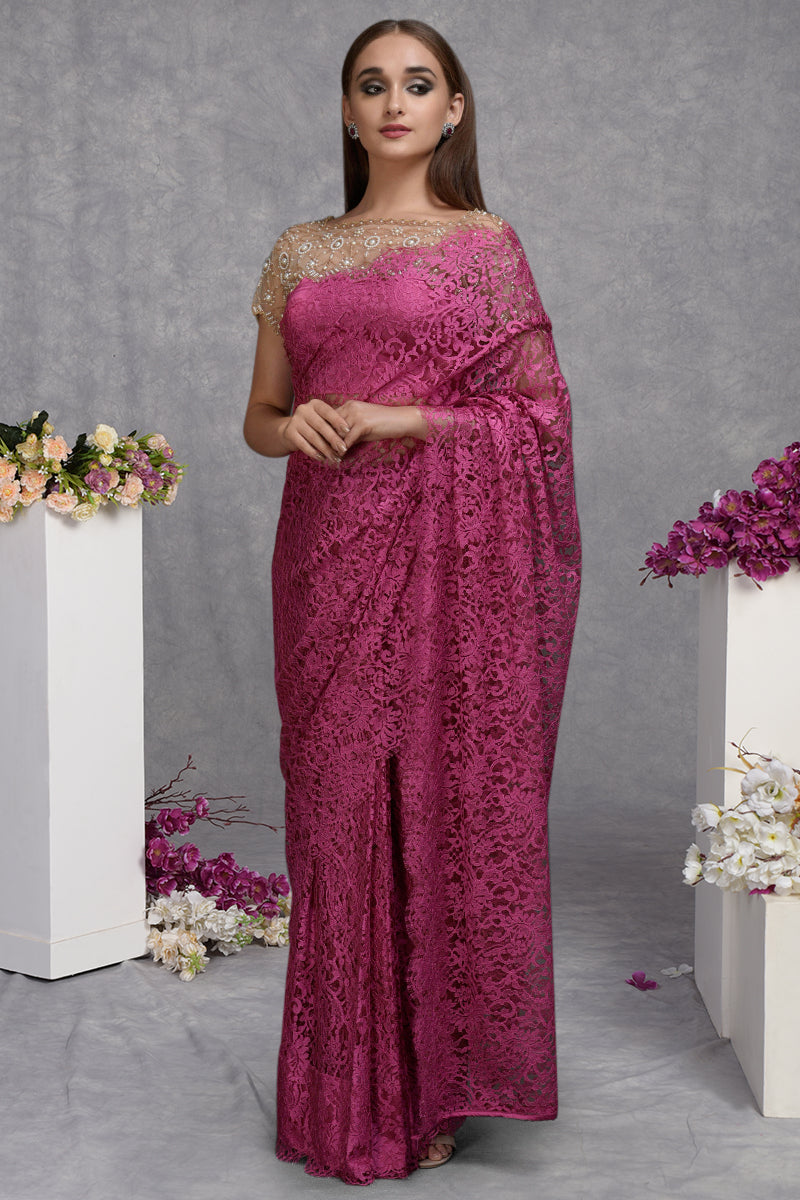A woman models a deep pink French Chantilly lace saree with a hand-embroidered blouse.