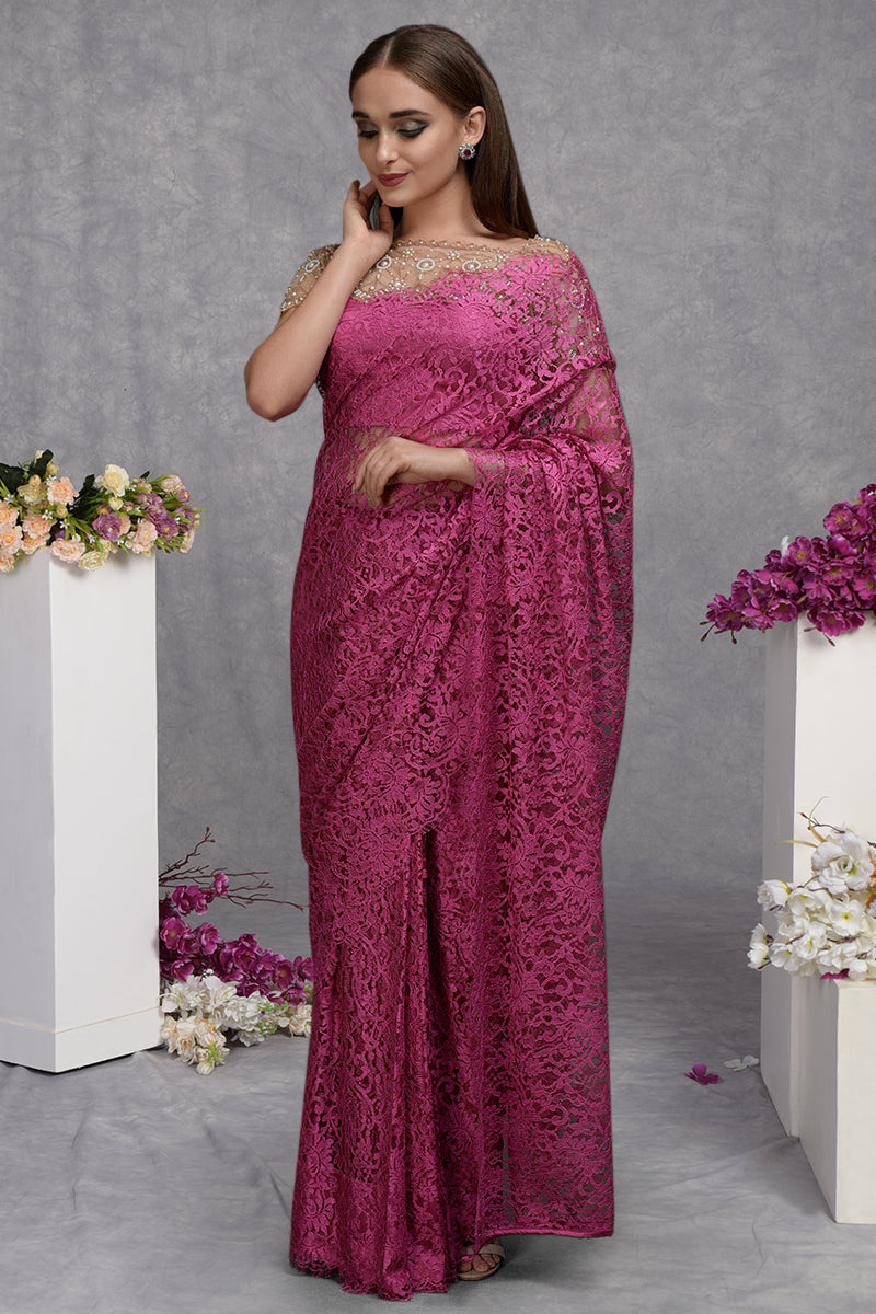 A woman models a deep pink French Chantilly lace saree with a hand-embroidered blouse.
