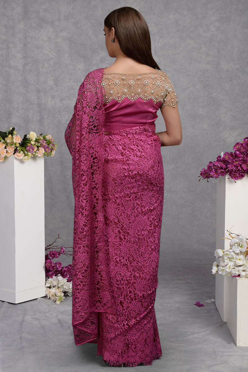 A woman from behind wears a deep pink French Chantilly lace saree with an embroidered blouse.