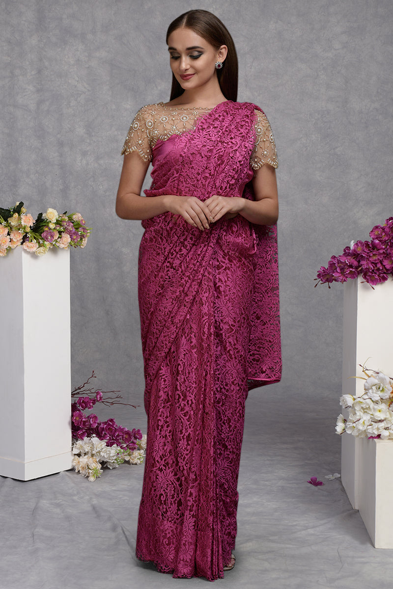 A woman models a deep pink French Chantilly lace saree with a hand-embroidered blouse.