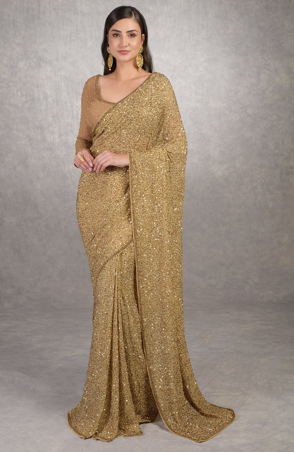 Gold chiffon saree with hand embroidered gold sequins and beads, paired with bronze scoop neck blouse.