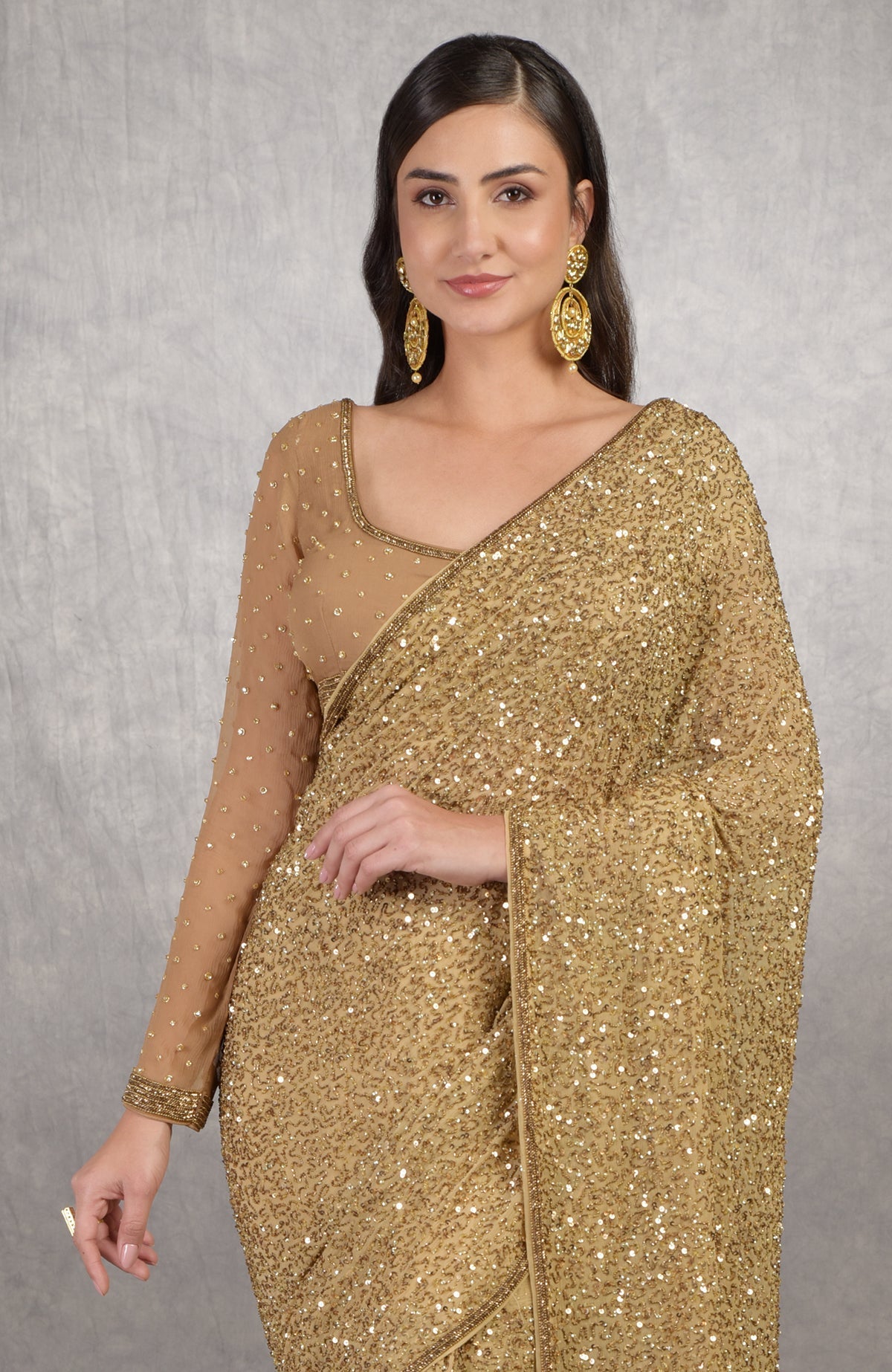 Gold Cleopatra saree with hand embroidered sequins and beads paired with bronze blouse.