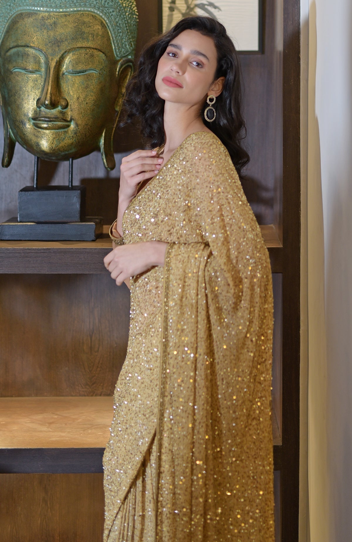 Gold chiffon saree with hand embroidered gold sequins and beads, paired with bronze blouse.