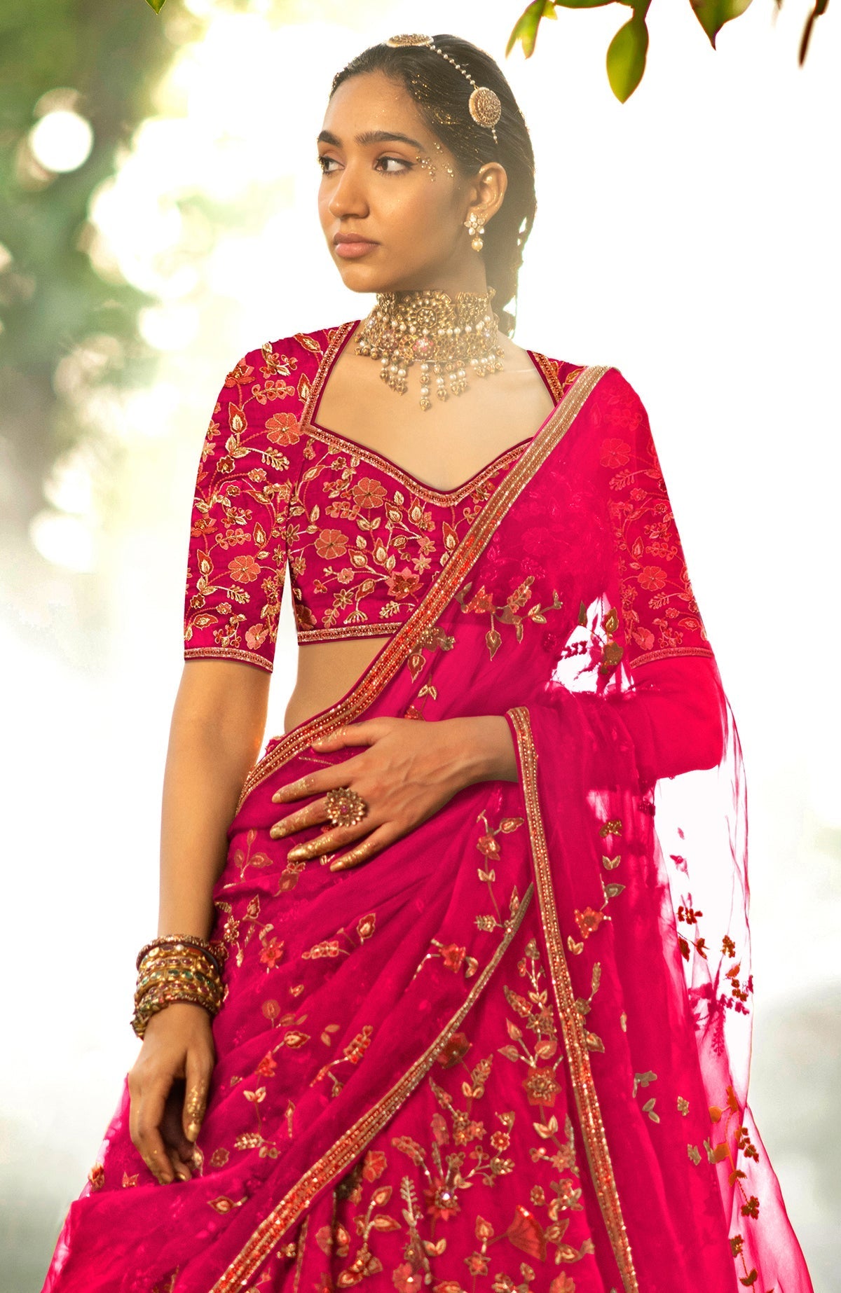 Pink lehenga set with floral embroidery, crystal accents, elbow-length sleeves, and silk organza veil.