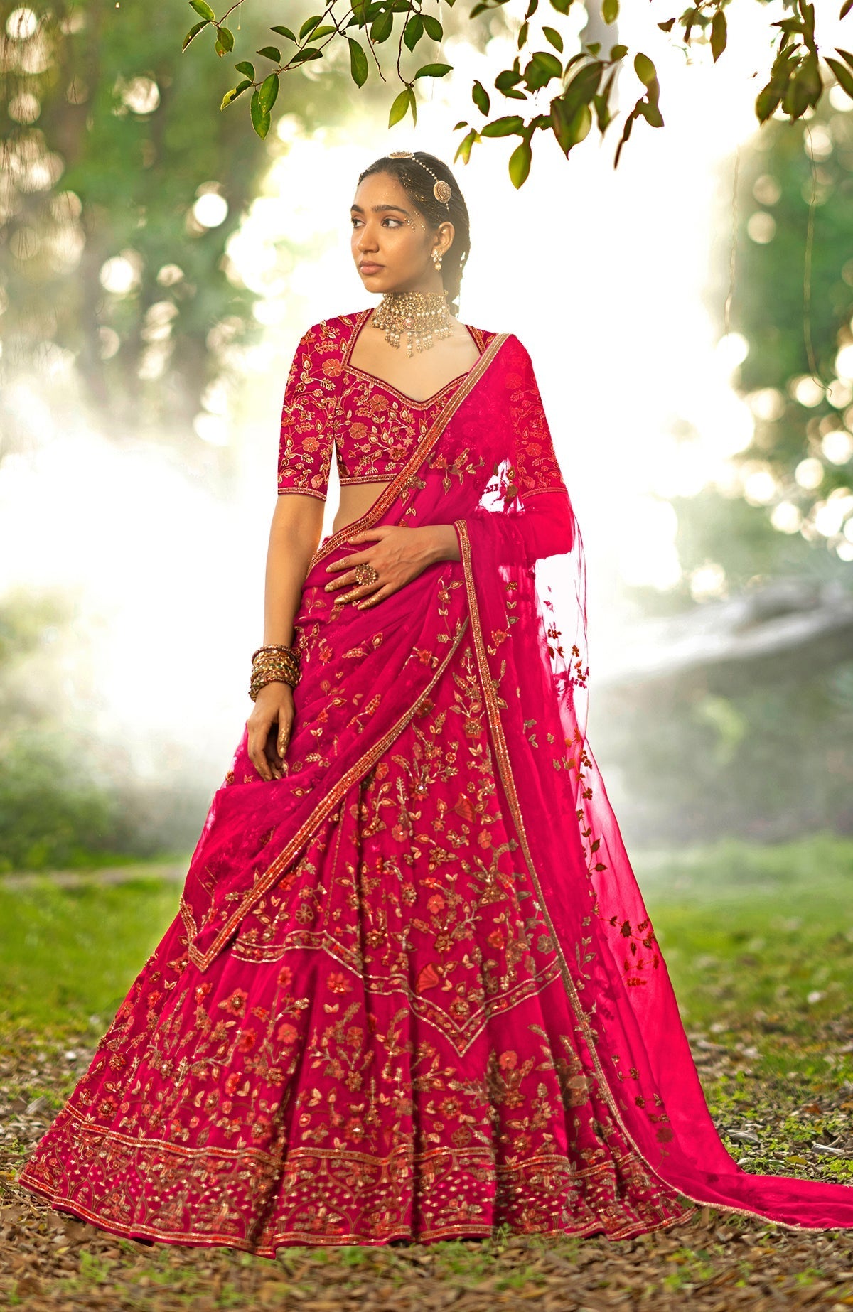 Pink lehenga set with floral embroidery, crystal accents, elbow sleeves, and silk organza veil.