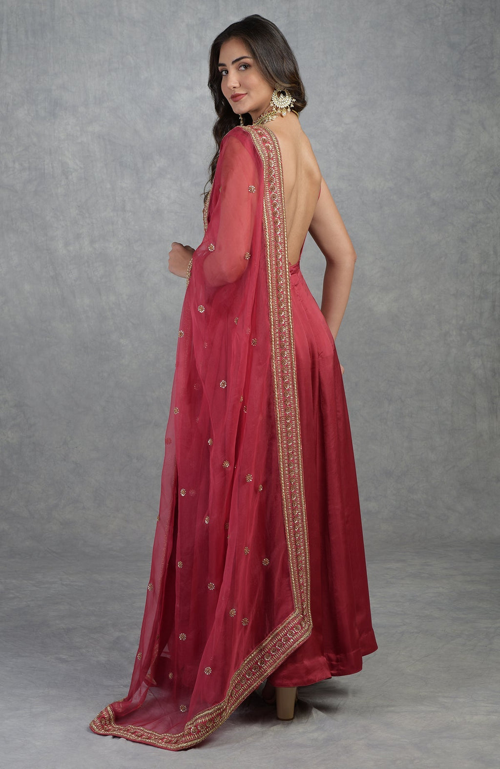 Garnet red hand-embroidered Anarkali set with flared silhouette and detailed zardozi work.