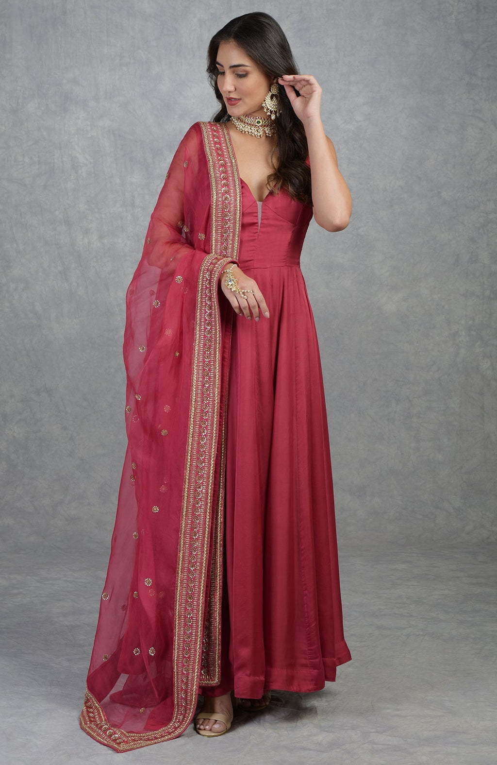 Garnet red Anarkali set with hand-embroidered zardozi work and organza dupatta with floral motifs.