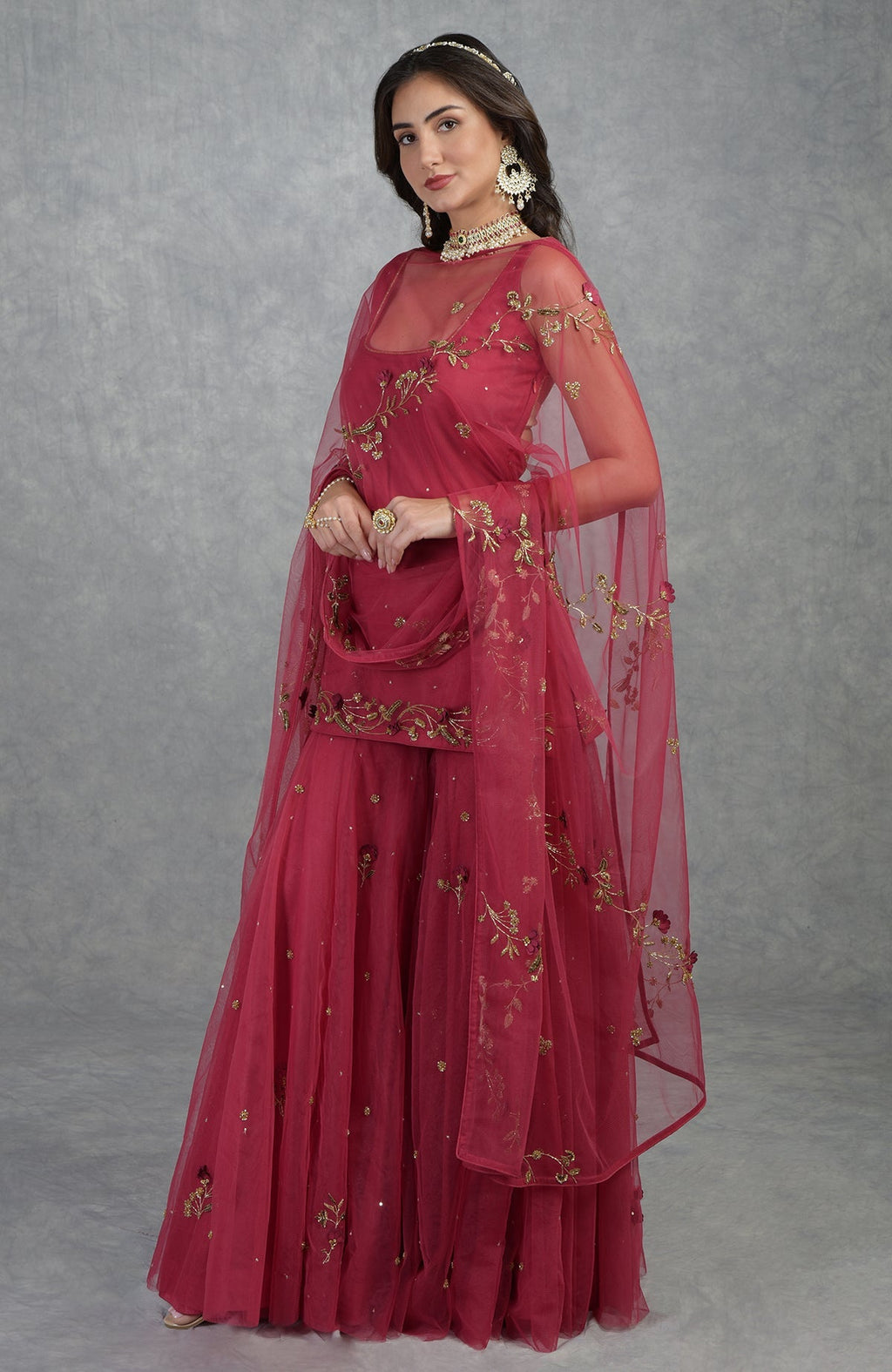 Red sharara set with 3D floral and zardozi hand embroidery on tulle fabric and matching dupatta.