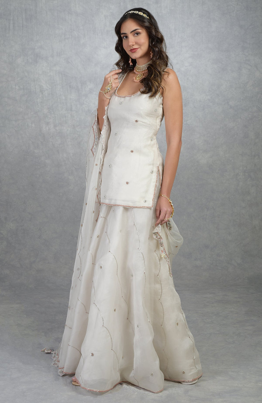 Off white silk organza sharara set with hand-embroidered floral beads, sequins, and scalloped dupatta edges