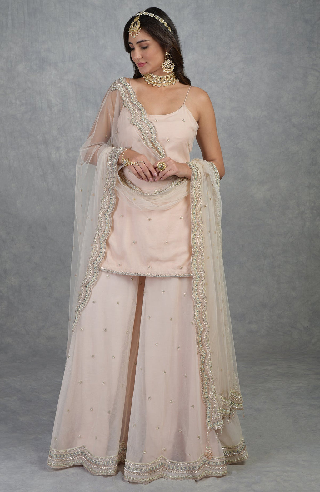 Champagne pink sharara set with hand-embroidered beads, sequins, crystals, and floral motifs.